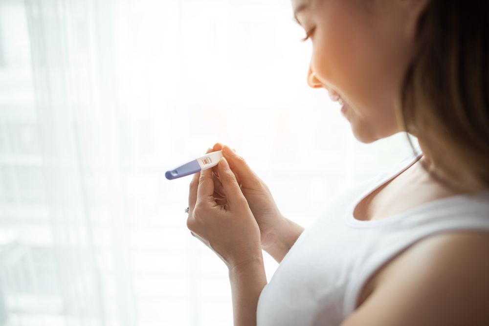 Young woman hand holding pregnancy test